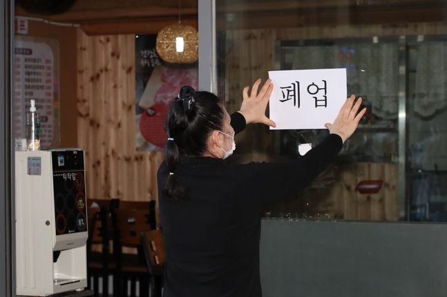 서울 동작구에서 식당을 운영하는 업주가 식당 문에 폐업이 적힌 종이를 붙이고 있다.ⓒ데일리안 류영주 기자