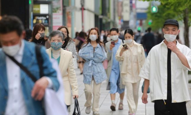 지난 13일 일본 도쿄에서 코로나19의 확산을 막기 위해 마스크를 쓴 사람들이 거리를 걷고 있다.ⓒAP/뉴시스