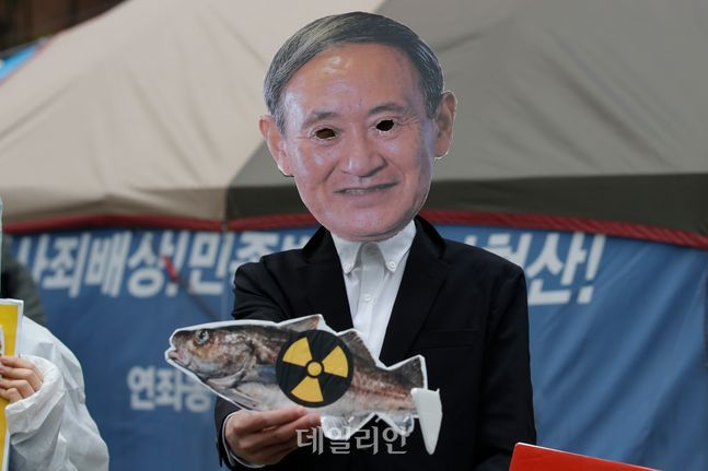 스가 요시히데 일본 총리의 가면을 쓴 환경운동가가 지난 13일 주한 일본대사관 인근에서 일본 정부의 결정을 규탄하는 퍼포먼스를 하고 있다. ⓒAP/뉴시스