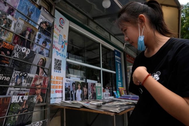 중국 베이징에서 한 여성이 연예잡지 등이 진열된 신문 가판대를 살펴보고 있다.ⓒ연합뉴스