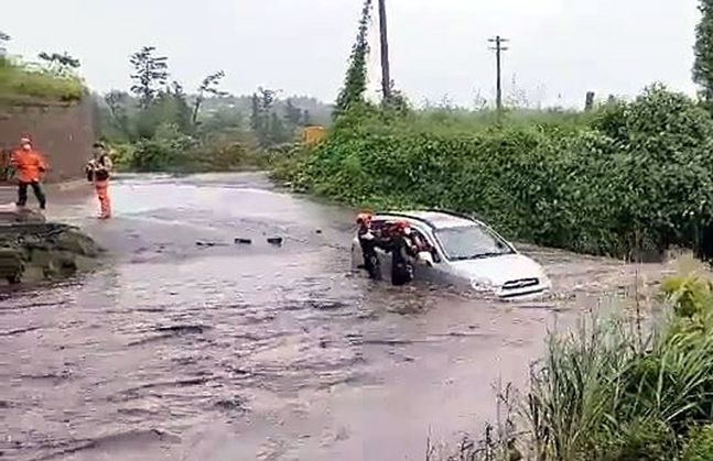 태풍 찬투의 간접 영향으로 제주에 많은 비가 내린 지난 14일 오전 소방대원들이 물에 잠긴 제주시 용강동의 한 도로에서 고립된 차 안의 운전자를 구조하고 있다. ⓒ연합뉴스