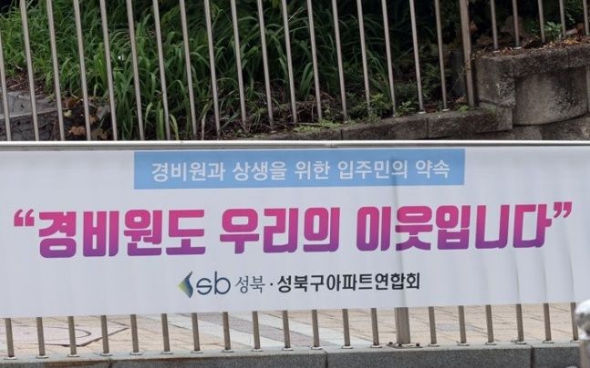 새 공동주택관리법 시행령이 시행된 21일 서울 성북구의 한 아파트 단지 내에 "경비원도 우리의 이웃입니다"라고 적힌 현수막이 걸려있다. ⓒ연합뉴스