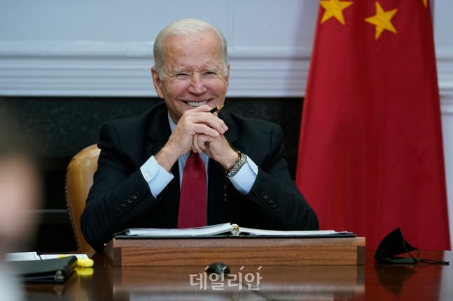 조 바이든 미국 대통령이 15일(현지시각) 백악관 루스벨트 룸에서 시진핑 중국 국가주석과 화상 정상회담을 하면서 웃고 있다. ⓒAP/뉴시스