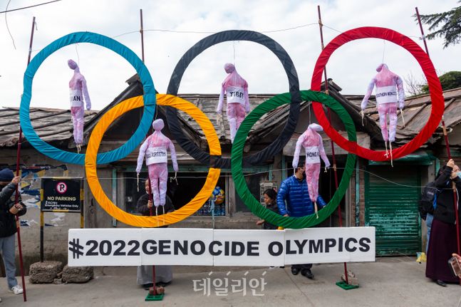 지난 2월 인도 다람살라에서 티베트인들이 베이징 동계올림픽 개최 반대 시위를 하면서 오륜에 다섯 개의 허수아비를 목매다는 퍼포먼스를 펼치고 있다. ⓒAP/뉴시스