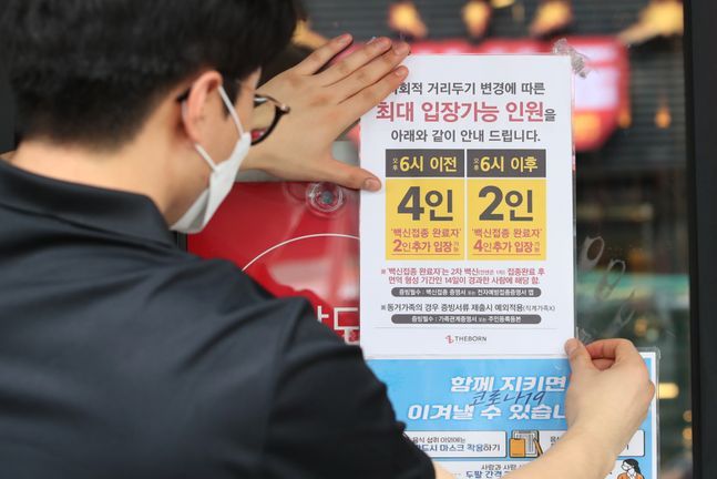지난 9월 6일 서울 종로구의 한 식당에서 직원이 새로운 사회적 거리두기 지침 관련 안내문을 부착하고 있다. ⓒ데일리안 류영주 기자