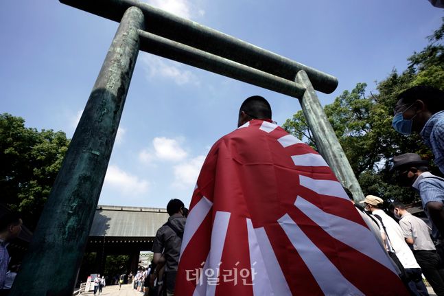 일본 도쿄의 야스쿠니 신사에서 한 남성이 욱일기를 몸에 두르고 참배 순서를 기다리고 있다(자료사진). ⓒAP/뉴시스