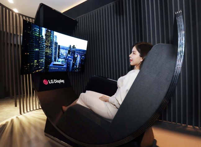 LG디스플레이 직원이 커브드 OLED와 리클라이닝 소파를 결합한 개인용 휴식공간 콘셉트 제품 '미디어 체어'를 체험하고 있다.ⓒLG디스플레이