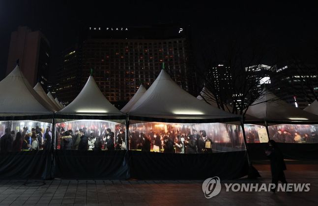 27일 저녁 서울광장에 마련된 선별진료소를 찾은 시민들이 줄을 서서 검사를 기다리고 있다. ⓒ연합뉴스