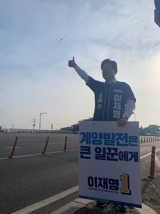 이재명 더불어민주당 인천 계양을 국회의원 보궐선거 후보가 24일 오전 계양IC 도로변에서 피켓을 들고 출근 인사를 하고 있다. ⓒ이재명 후보 캠프