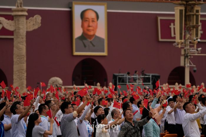 Pessoas agitam uma bandeira de cinco estrelas sob uma grande foto do falecido presidente Mao Zedong durante uma cerimônia para comemorar o centenário da fundação do Partido Comunista da China na Praça Tiananmen em Pequim, China, em 1º de julho.  ⓒAP / Notícias
