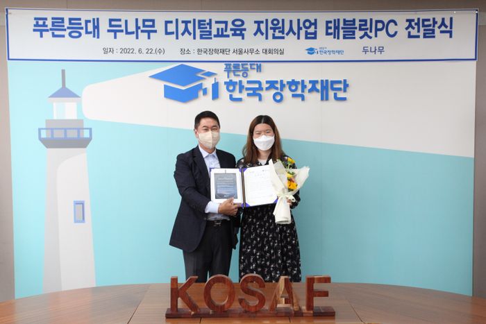 지난 22일 한국장학재단 서울사무소에서 진행된 '푸른등대 두나무 디지털교육 지원사업 태블릿PC 전달식'에서 이석우 두나무 대표이사(왼쪽)가 장학증서와 디지털기기를 전달하고 있다.ⓒ두나무