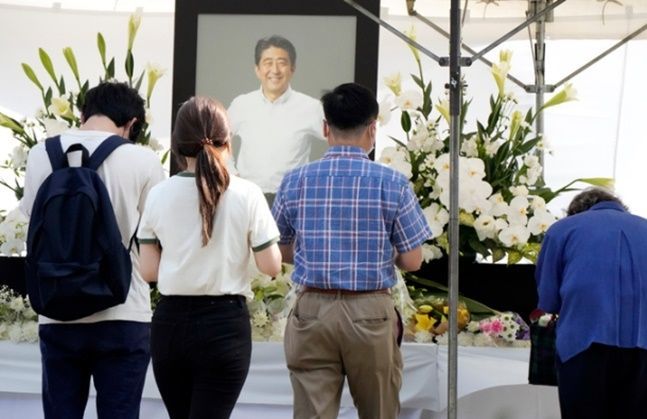 지난 7월11일 일본 도쿄 미나토구의 사찰 조죠지 사찰을 찾은 시민들이 아베 신조 전 총리의 헌화대에서 조문하고 있다. ⓒAP/뉴시스