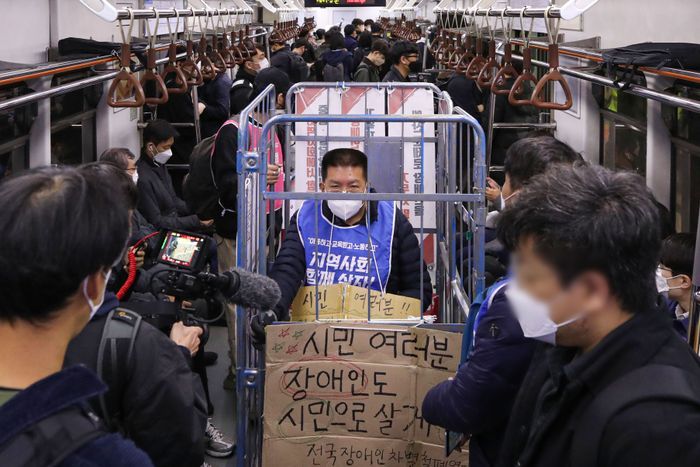 전국장애인차별철폐연대(전장연) 회원들이 지난 10월 25일 오전 서울 용산구 삼각지역에서 장애인권리예산 등을 촉구하는 '제41차 출근길 지하철 탑니다' 시위를 하고 있다.ⓒ뉴시스