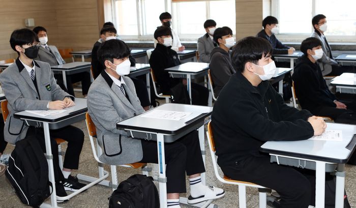 전북 전주시 동암고등학교 1학년 학생들이 마스크를 쓴 채 교사에게 학교생활을 안내받고 있다.ⓒ연합뉴스