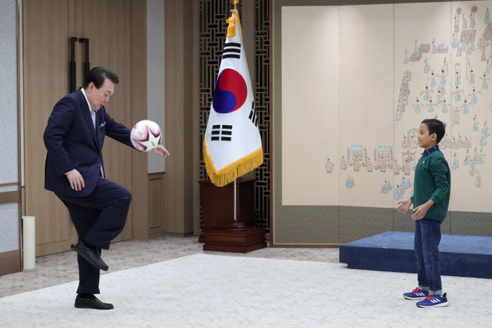 윤석열 대통령이 31일 서울 용산 대통령실 청사에서 캄보디아 소년 로타를 만나 축구를 하고 있다. ⓒ대통령실실