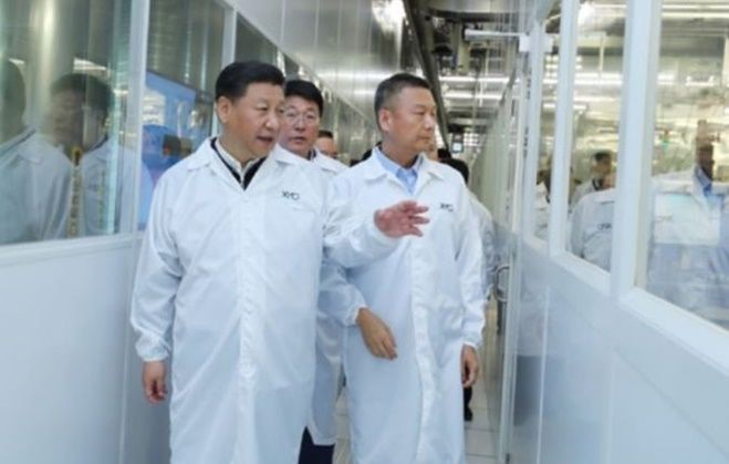 시진핑(왼쪽) 중국 국가주석이 2018년 중국 후베이성 우한에 있는 창장춘추 공장에서 자오웨이궈(가운데) 당시 쯔광그룹 회장, 양스닝(오른쪽) 창장춘추 당시 최고경영자와 함께 반도체 생산 라인을 둘러보고 있다. ⓒ 쯔광그룹 홈페이지 캡처