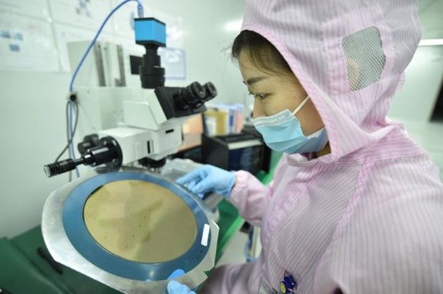 지난 2월 중국 장쑤성 쑤첸시에 있는 한 반도체 제조공장에서 한 직원이 반도체 웨이퍼를 살펴보고 있다. ⓒ AFP/연합뉴스
