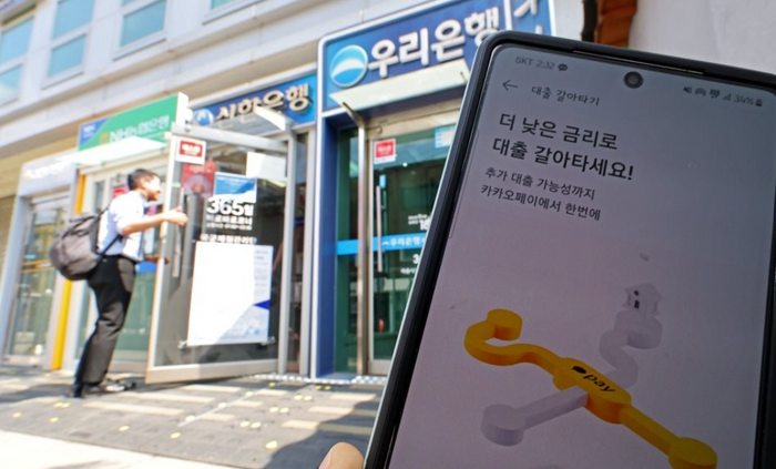 금융권의 온라인·원스톱 대환대출 플랫폼이 시행된 31일 오후 서울 시내에 설치된 시중은행들의 ATM기와 카카오페이 대출 비교 서비스 '대출 갈아타기' 화면 모습. ⓒ연합뉴스