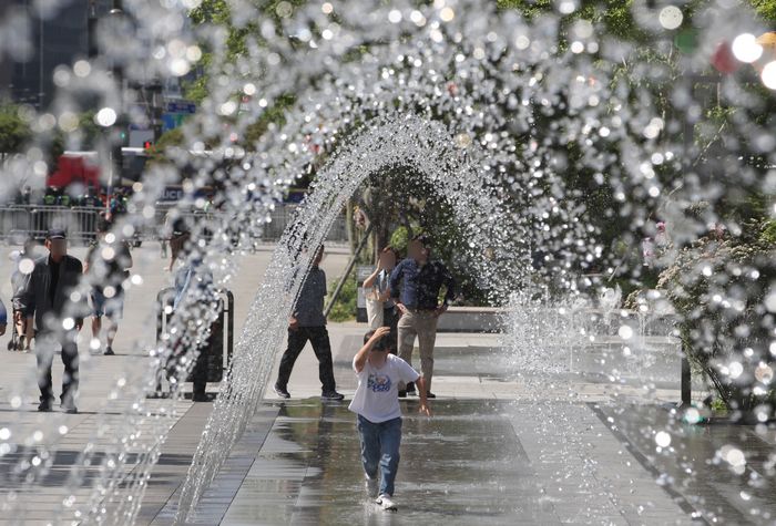 서울 광화문광장 분수대에서 시민들이 시원한 물줄기를 보고 있다.ⓒ뉴시스