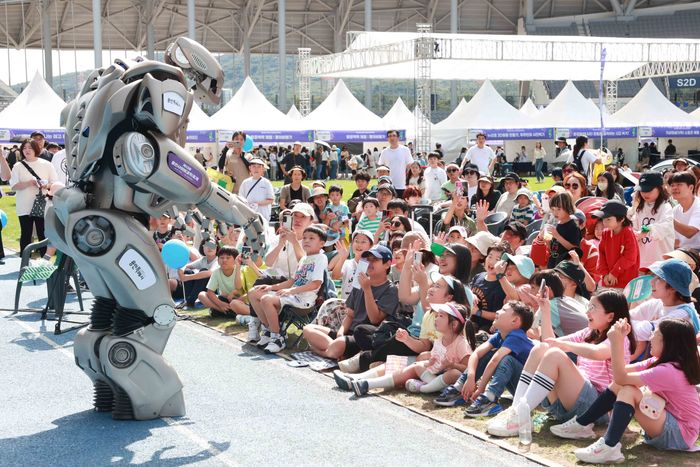 어린이들이 제23회 용인 사이버 과학 축제에 등장한 로봇 타이탄과 즐거운 한 때를 보내고 있다.ⓒ용인시 제공