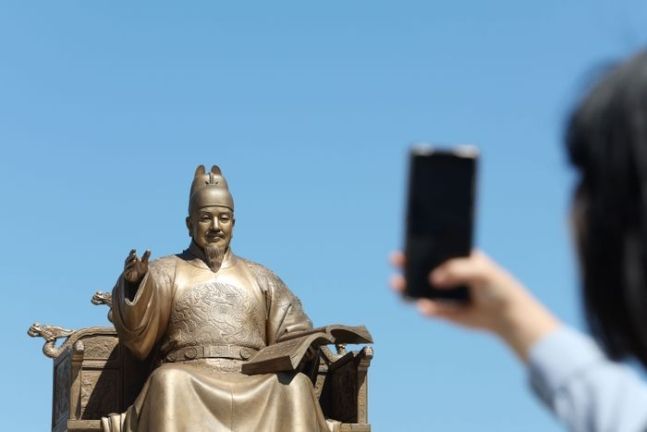 한 시민이 서울 종로구 광화문 광장에서 세종대왕 동상을 촬영하고 있다. ⓒ데일리안 김민호 기자