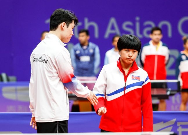 지난달 28일 중국 항저우 궁수 커낼 스포츠파크에서 열린 2022 항저우 아시안게임 탁구 혼성 복식 16강전 대한민국과 북한과의 경기에 앞서 북한 김금용이 장우진의 악수를 피하고 있다. ⓒ 뉴시스