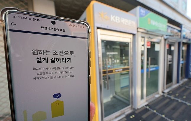 휴대전화 뱅킹 애플리케이션과 서울 시내 거리의 은행 현금자동입출금기(ATM) ⓒ 연합뉴스