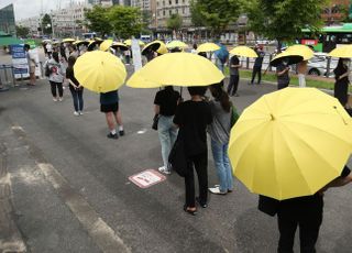 무더위에 노란 우산 쓰고 기다리는 코로나19 검사