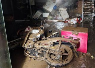 침수 피해 현장에 진흙으로 뒤덮힌 오토바이